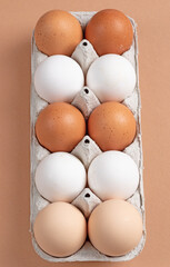 fresh eggs in a carton of three colors. Top view