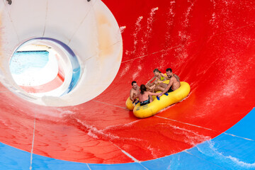 Friends having fun on huge water slide in aqua park