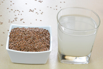 Flaxseed water in a glass cup and flaxseeds  in a bowl