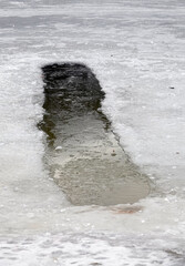 Big ice hole in the lake in winter