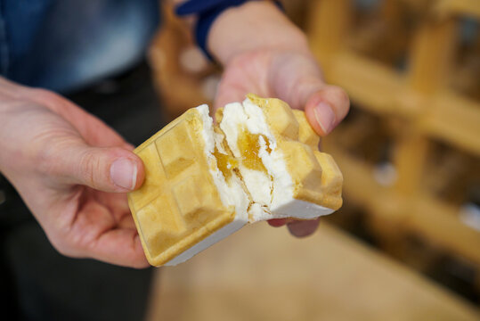 Yuzu Ice Cream Sandwich. Hand Holding A Crispy Wafer Stuffed With Yuzu Fruit Ice Cream And Jam.