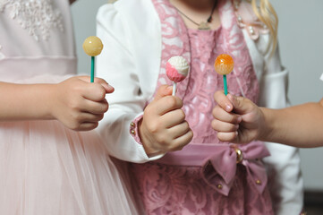 Children eating lollipops on a stick close up