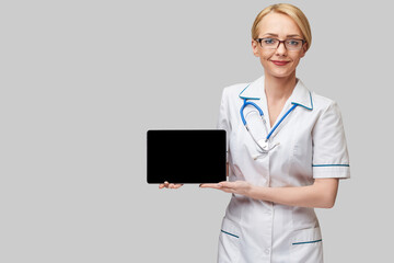 beautiful female doctor holding tablet pc pad isolated on grey background