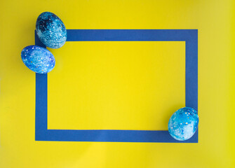 Colorful eggs on a yellow background, lying flat. Greeting card with space for text