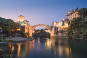 Foto op Plexiglas Stari Most Night cityscape view of the iconic illuminated Stari Most bridge, Neretva River and old town of Mostar, Bosnia and Herzegovina.