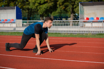 Obraz premium Sportive guy is ready to run at the stadium