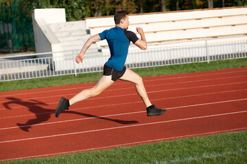 Fototapeta premium Male runner doing workout at the stadium