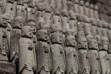 Japanese small praying Buddha statues at temple in Kamakura, Japan