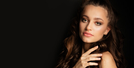 Adorable woman posing on a black background at studio