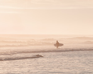 Surfer going into the sea 