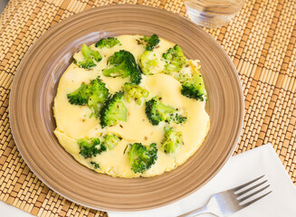 wholesome breakfast. omelet with broccoli on brown plate