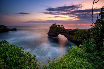 Sunset at Batu Bolong temple and Tanah Lot, Tabanan, Bali. beautiful view from the towpath stunning color in high tide.