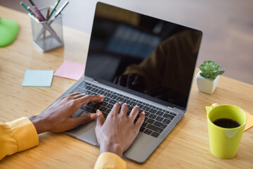 Fototapeta premium Photo of girl hands typing on laptop table wear yellow shirt at home