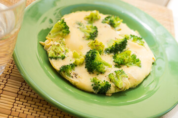 wholesome breakfast. omelet with broccoli on green plate