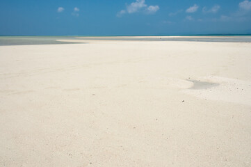 Low tide scenery exposing its white sands contrasting the blue sky of Kondoi beach. Taketomi Island.