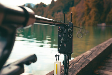 Electronic indicator, bite alarm, Spinning reel on a green blurred background. Concept: outdoor...