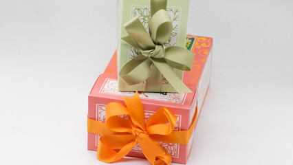 Green gift box on the pink box with bows for a celebration