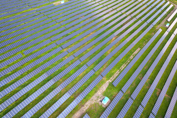 Aerial view of solar power plant on green field. Electric panels for producing clean ecologic energy.