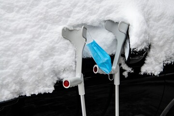 Schwierige Situation, Gehhilfen und eine Mund- Nasenbedeckung an einem verschneiten Auto -...