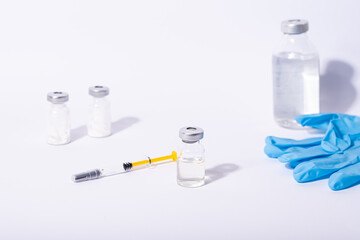Coronavirus vaccine. Some ampoules and syringe with ncov-2019 vaccine in a box on blue background.
