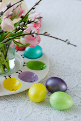 Easter still life with a bouquet of tulips and willow, Easter eggs and cake in pastel colors