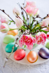 Easter still life with a bouquet of tulips and willow, Easter eggs and cake in pastel colors