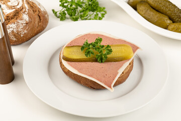 Liver pate cut on a bun with parsley and cucumber