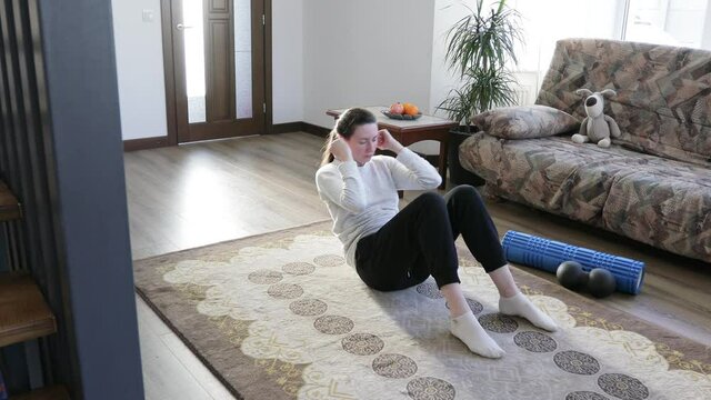 Woman doing physical exercises at home in the morning