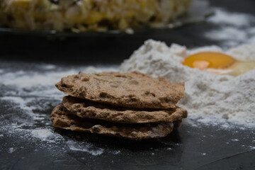 The process of making a cake. Cake cakes, flour and raw egg on a dark background