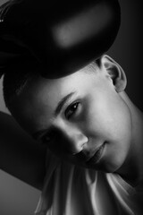 Young woman with short hair in boxing gloves on a white background. Monochrome photo