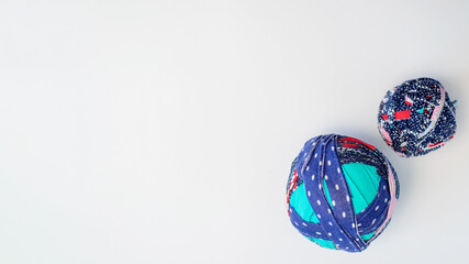 Rag balls of different fabrics on a white background. Flat lay, copy space. Recycled material from T-shirts for knitting rugs.