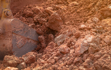 Backhoe working by digging soil at construction site. Bucket teeth of backhoe digging soil. Crawler excavator digging on soil. Excavating machine. Earth moving machine. Excavation vehicle.