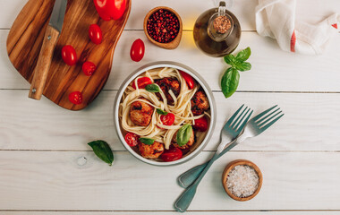 Italian pasta with chicken meatballs, tomatoes and basil.