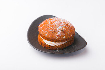 Photo of tasty cake with white cream over white background.