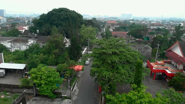 Aerial footage small road view and neighbourhood in Yogyakarta city from drone flying above the trees
