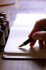 Close-up of a fountain pen on a notebook and several inkwells. Concept of writing poetry. International Poetry Day