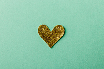 Shiny golden Heart shape sticker on green background