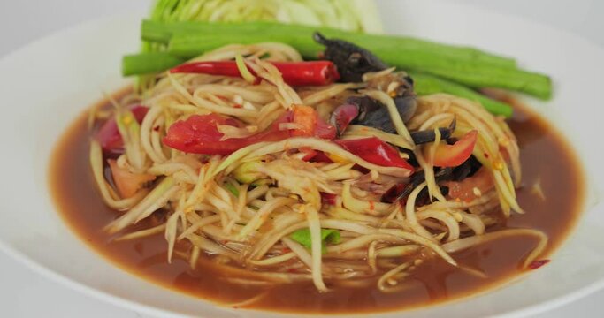 Papaya salad or som tam spicy with crab and pickled Fish on white background. Popular Thai food.