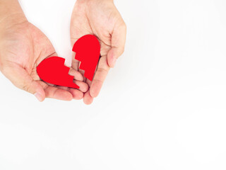 Two men's hands wrapped in red heart paper that was split into two. On a white background