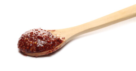 Dijon blackcurrant liqueur mustard with wooden spoon isolated on white background