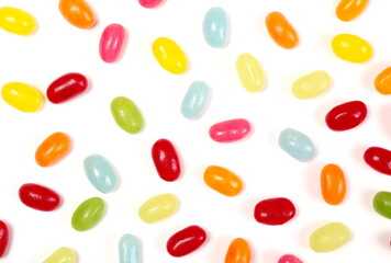 Sour jellybeans, colorful fruit candy dessert snack pile isolated on white background, top view