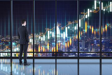 New height concept with businessman on the roof of skyscraper looking at night city and digital display with glowing financial graphs. Double exposure.