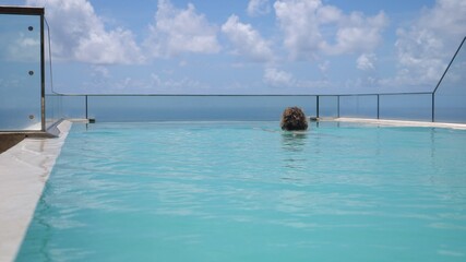 Obraz premium Luxury vacations at the hotel with the infinity swimming pool overlooking an ocean