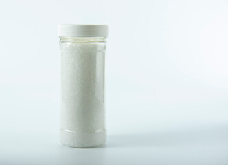 Transparent jar with salt on a light background.
