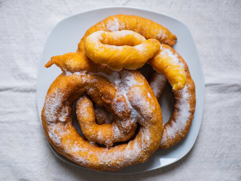 Woman frying vegan cattas sweet fritters, Sardinian Carnival cakes