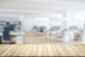 Empty wooden tabletop with modern furnished office on background, mock up
