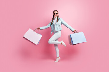Full body photo of young excited girl happy positive smile go walk jump hold bag shopping isolated...