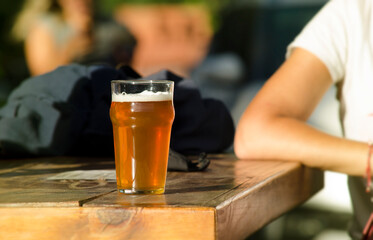 young man sitting at a table with a glass of craft beer