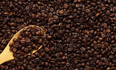 Bunch of coffee beans on a wooden spoon with a coffee bean background for coffee lovers