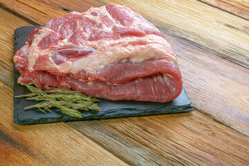 Raw pork ribs. Top the meat ingredient on a slate serving board. close-up.Selective Focus